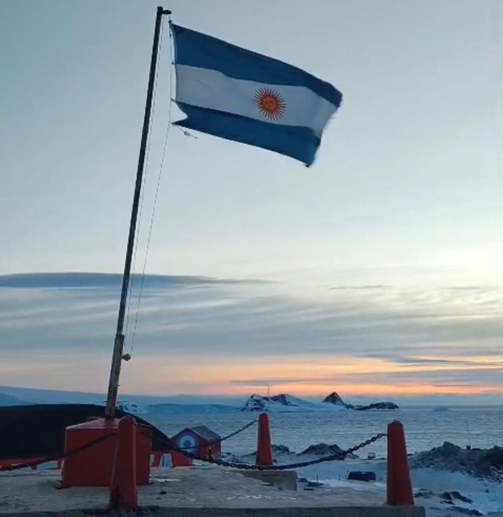 Izamiento de la Bandera Nacional en una base antártica argentina durante la conmemoración del Día de la Bandera